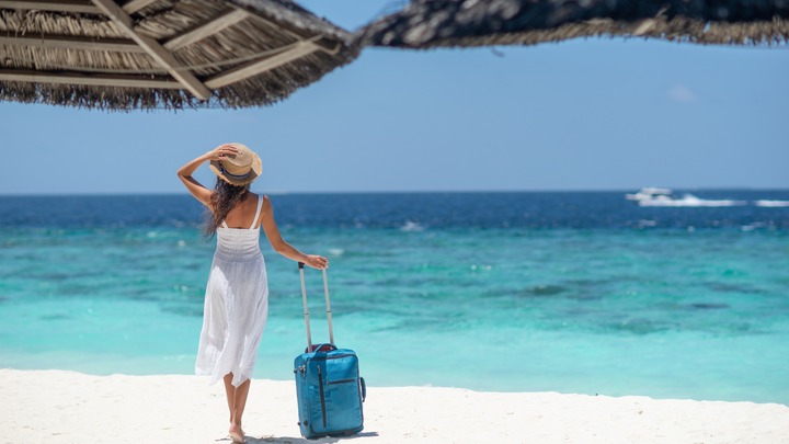 Frau steht am Strand, verlinkt zum Blogbeitrag Reiseversicherungen - Schutz für einen sorglosen Urlaub!