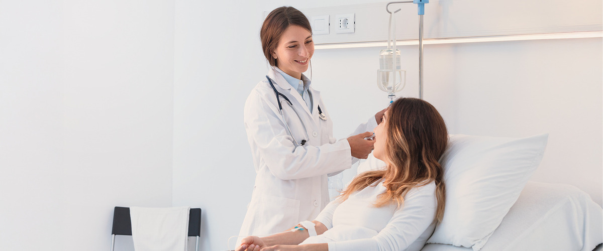 Bild zeigt Ärztin behandelt Patientin im Bett verlinkt zum Blogbeitrag Krankenzusatzversicherung = Gesundheit Plus