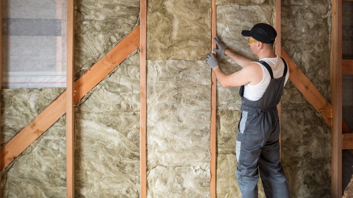 Bild zeigt Handwerker der an Dämmschutz arbeitet verlinkt zum Blogbeitrag Effiziente Sanierungsfinanzierung trotzt dem Zinsaufschwung